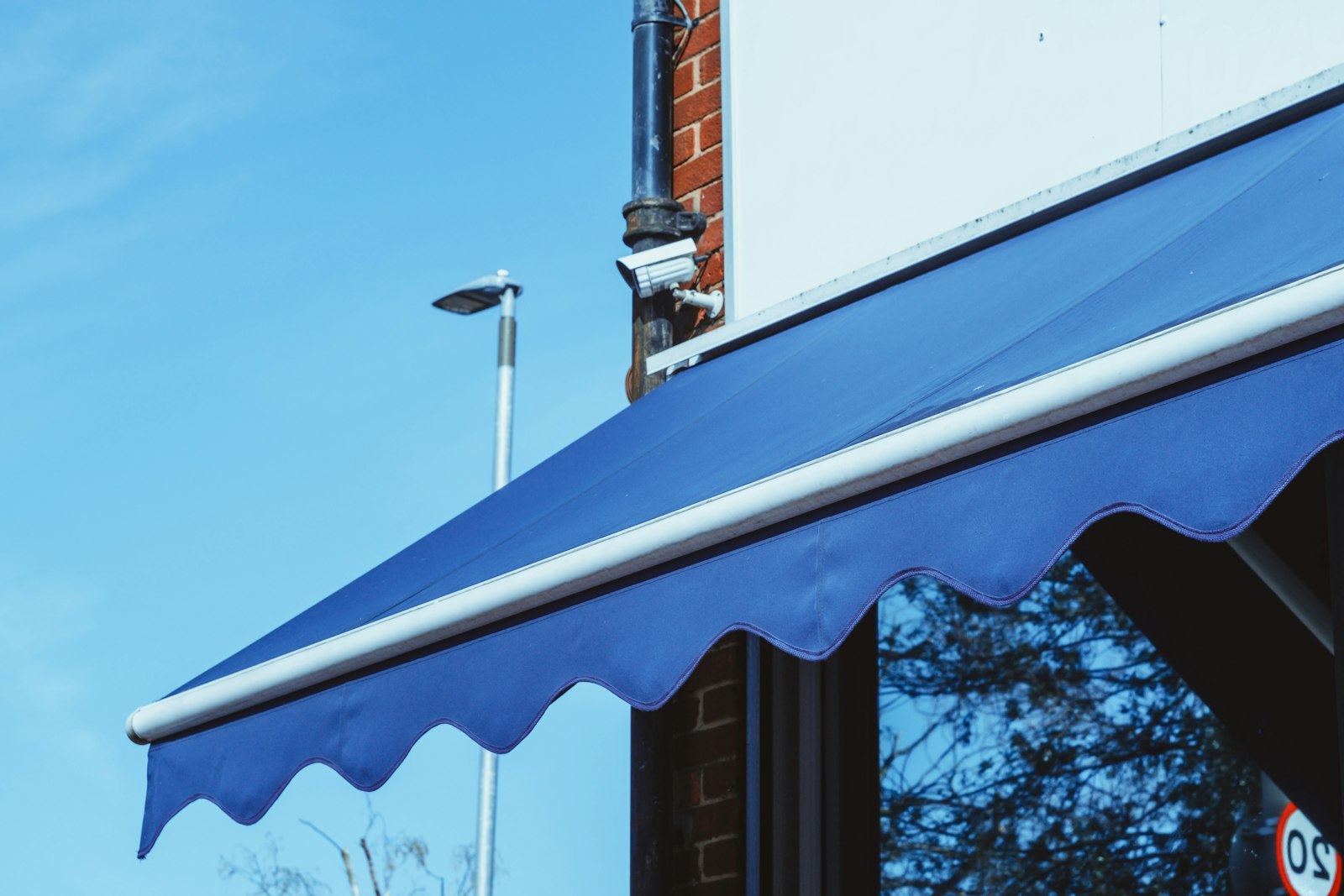 Toldo de brazo extensible abierto con su barra de carga